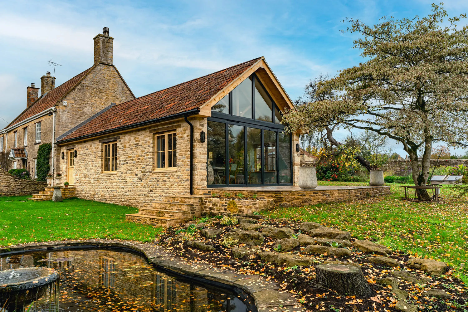 Stone house with large glass windows in a garden setting