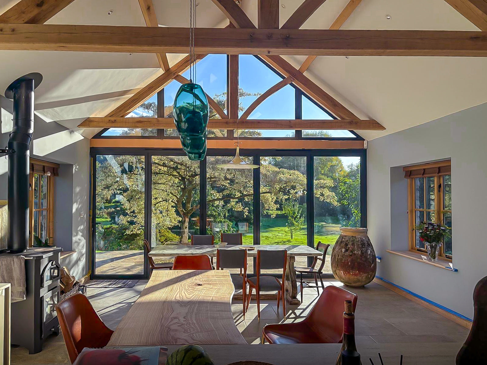 Modern interior with wooden beams, large glass windows, and a dining area.